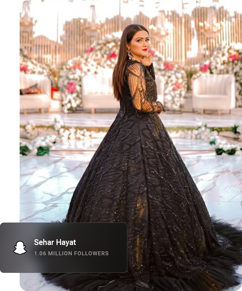 Youtube influencer looking away from the camera and smiling while sitting on a curb.