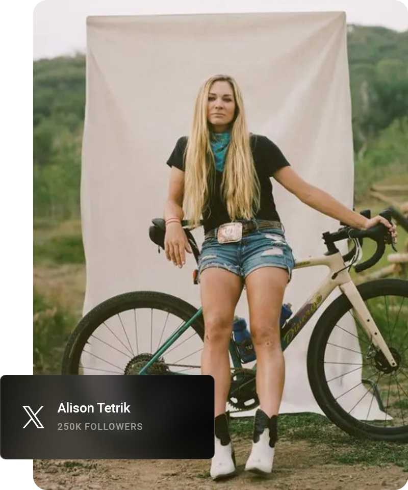 Youtube influencer looking away from the camera and smiling while sitting on a curb.